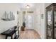 Bright and airy foyer showcasing wood floors, decorative wall accents, and a glimpse of the inviting living spaces beyond at 13190 Se 93Rd Cir, Summerfield, FL 34491