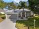Well-maintained one-story home with a gray roof, a two-car garage, and landscaped front yard at 13190 Se 93Rd Cir, Summerfield, FL 34491