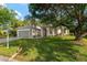 Single-story home with a green lawn and mature trees surrounding the property at 13190 Se 93Rd Cir, Summerfield, FL 34491