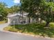 Charming single-story home with a well-manicured lawn, a tree, and an attached two-car garage at 13190 Se 93Rd Cir, Summerfield, FL 34491
