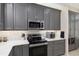 Modern kitchen features gray cabinetry, stainless steel appliances, and ample counter space at 13190 Se 93Rd Cir, Summerfield, FL 34491