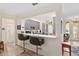 Modern kitchen featuring sleek gray cabinetry and a breakfast bar with stylish seating at 13190 Se 93Rd Cir, Summerfield, FL 34491