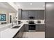 Updated kitchen with gray cabinets, stainless appliances, modern backsplash, and countertops at 13190 Se 93Rd Cir, Summerfield, FL 34491