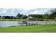 Scenic lake view with a wooden dock and gazebo, perfect for outdoor relaxation and community gatherings at 13190 Se 93Rd Cir, Summerfield, FL 34491