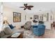 Well-lit living area featuring hardwood floors, comfortable sofas, and a view into the kitchen at 13190 Se 93Rd Cir, Summerfield, FL 34491
