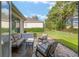 Outdoor patio with comfortable seating, a stone-accented area, and a well-maintained lawn at 13190 Se 93Rd Cir, Summerfield, FL 34491