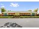 Attractive clubhouse with green tile roof, black fence, and well-maintained landscaping at 132 Palermo Pl, The Villages, FL 32159