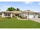 Well-maintained home featuring a lush front lawn, charming landscaping, and a three car garage at 132 Palermo Pl, The Villages, FL 32159