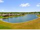 Scenic view of a tranquil pond surrounded by lush greenery and well-maintained residential properties at 132 Palermo Pl, The Villages, FL 32159