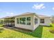 Bright sunroom with large windows overlooking the landscaped backyard and a screened-in porch at 132 Palermo Pl, The Villages, FL 32159