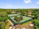 Aerial view of tennis courts surrounded by lush greenery, palm trees, and beautiful landscaping at 132 Palermo Pl, The Villages, FL 32159