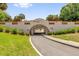 Charming tunnel entrance with brick accents, landscaping, and a smooth, paved road at 132 Palermo Pl, The Villages, FL 32159