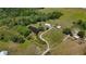 Panoramic aerial view of the property featuring a home, a pond, and two outbuildings at 15141 Farm Rd, Groveland, FL 34736