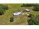 Aerial view featuring the home, grounds, outbuildings and mature landscaping at 15141 Farm Rd, Groveland, FL 34736