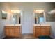 Bathroom featuring separate sinks and a central door leading to additional bathroom features at 15141 Farm Rd, Groveland, FL 34736