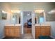 Dual sink bathroom with an open door leading into the spacious main bedroom at 15141 Farm Rd, Groveland, FL 34736