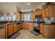 Kitchen with tile floors, stainless-steel appliances, and bright wood cabinets at 15141 Farm Rd, Groveland, FL 34736