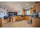 Kitchen featuring tile floors, wood cabinets, and open view into adjacent living room at 15141 Farm Rd, Groveland, FL 34736