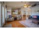 Open-concept living room featuring hardwood floors, two chairs, blue sofa, and area rug at 15141 Farm Rd, Groveland, FL 34736