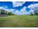Pasture with perimeter fencing and blue skies with mature trees at 15141 Farm Rd, Groveland, FL 34736