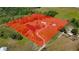 Aerial view highlighting property lines surrounding the home, outbuildings, and pond at 15141 Farm Rd, Groveland, FL 34736