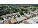 Wide aerial shot of a neighborhood with a pond and mature trees in the background at 1667 Osprey Ave, The Villages, FL 32162