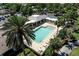 Aerial view of a large community pool with lounge chairs and mature palm trees at 1667 Osprey Ave, The Villages, FL 32162
