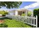 Delightful home with charming curb appeal, featuring a white picket fence, attractive landscaping, and a cozy screened lanai at 1667 Osprey Ave, The Villages, FL 32162
