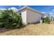 Tan home exterior surrounded by rock landscaping and greenery offering privacy at 1667 Osprey Ave, The Villages, FL 32162