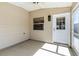 Cozy screened-in lanai featuring neutral walls and floor, with a ceiling fan and access door at 1667 Osprey Ave, The Villages, FL 32162