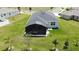 Aerial view of a backyard featuring a screened-in patio, well-kept lawn, and surrounding greenery at 1688 Littleleaf Boxwood Loop, Mascotte, FL 34753