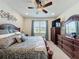 Comfortable primary bedroom featuring a large bed, dresser, and a window with natural light at 1688 Littleleaf Boxwood Loop, Mascotte, FL 34753