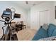Neutral bedroom with a blue sofa, elliptical machine, TV and closet at 1688 Littleleaf Boxwood Loop, Mascotte, FL 34753