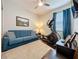 Neutral bedroom with a blue sofa, elliptical machine, ceiling fan and curtains at 1688 Littleleaf Boxwood Loop, Mascotte, FL 34753