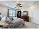 Bright bedroom offering natural light, dark wood furniture, and plush bedding at 1688 Littleleaf Boxwood Loop, Mascotte, FL 34753