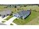 Aerial view of a home with a long driveway, lush lawn, and view of a pond and open space at 1688 Littleleaf Boxwood Loop, Mascotte, FL 34753