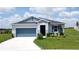 Charming single-story home with a blue garage door, blue accents, and inviting curb appeal at 1688 Littleleaf Boxwood Loop, Mascotte, FL 34753