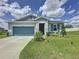 Charming single-story home with well-maintained lawn, blue accents, and two-car garage at 1688 Littleleaf Boxwood Loop, Mascotte, FL 34753
