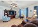 Cozy living room with a large entertainment center, comfortable seating, and natural light from a window at 1688 Littleleaf Boxwood Loop, Mascotte, FL 34753