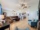 Spacious living room featuring an open-concept layout, wood flooring, and views of the kitchen and dining areas at 1688 Littleleaf Boxwood Loop, Mascotte, FL 34753