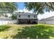 Large, green backyard with white fencing and a covered patio extending from the home at 1704 Hoofprint Court, Fruitland Park, FL 34731