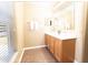 Bright bathroom with a double vanity, neutral walls, tiled floors, and natural light from a window at 1704 Hoofprint Court, Fruitland Park, FL 34731