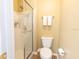 Clean bathroom featuring a glass-enclosed shower, toilet, and towel rack for convenience at 1704 Hoofprint Court, Fruitland Park, FL 34731