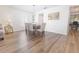 Dining area with wood floors, neutral chairs, table, and modern lighting fixture at 1704 Hoofprint Court, Fruitland Park, FL 34731