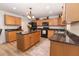 Well-equipped kitchen boasts wood cabinets, granite countertops, and a functional center island at 1704 Hoofprint Court, Fruitland Park, FL 34731
