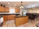 Open kitchen featuring wood cabinetry, granite countertops, and modern appliances at 1704 Hoofprint Court, Fruitland Park, FL 34731