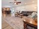 Open-concept living space with wood floors, a dark leather sofa, and seamless connection to the kitchen area at 1704 Hoofprint Court, Fruitland Park, FL 34731