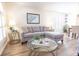 Comfortable living room featuring wood floors, a plush grey sofa, and decorative accents at 1704 Hoofprint Court, Fruitland Park, FL 34731