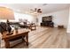Spacious living room with hardwood floors, a ceiling fan, and comfortable seating around a wooden coffee table at 1704 Hoofprint Court, Fruitland Park, FL 34731
