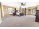 Large main bedroom with a four-poster bed, neutral carpet, multiple windows, and generous space at 1704 Hoofprint Court, Fruitland Park, FL 34731